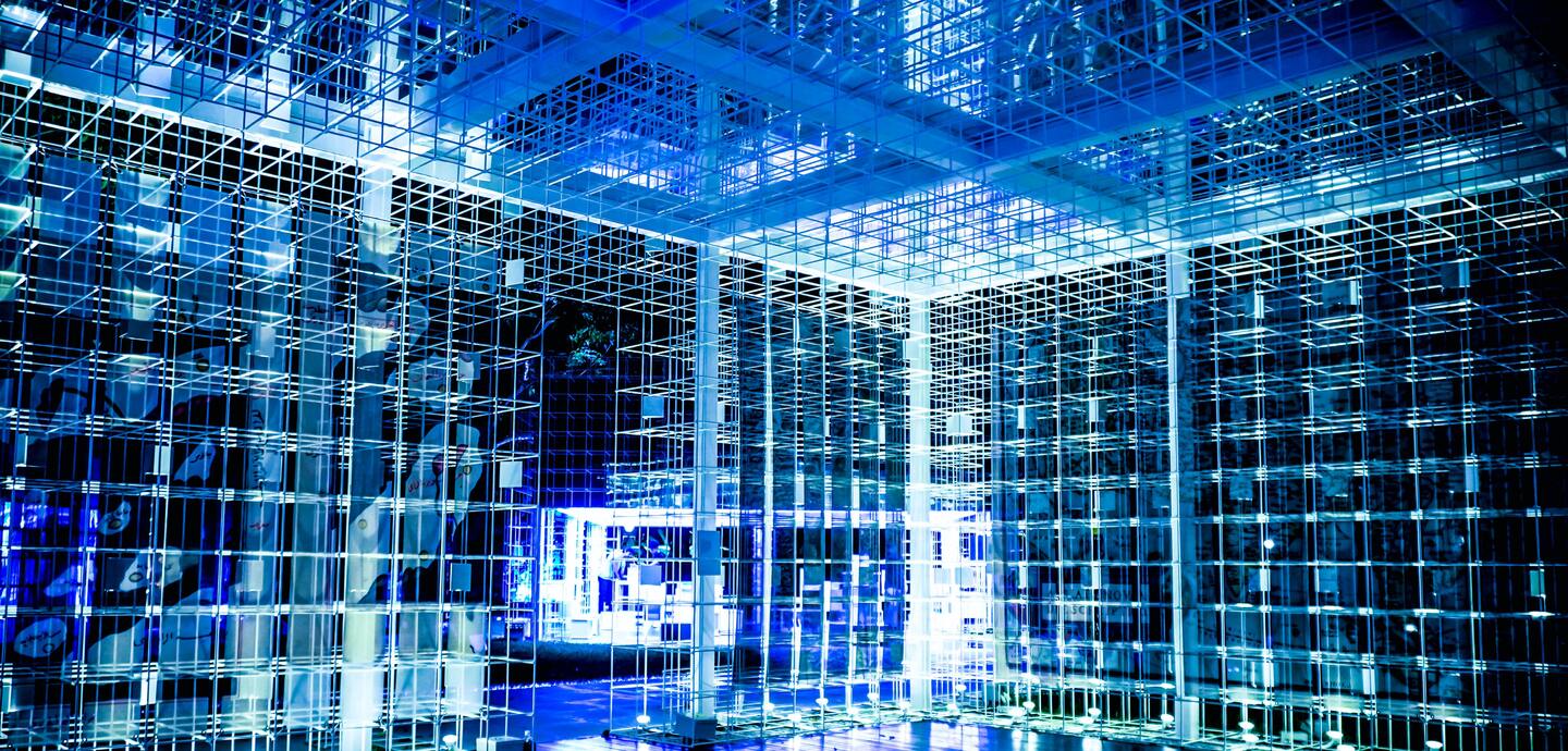 Ein futuristisches Innenraumdesign mit blau beleuchteten Metallstrukturen und reflektierenden Oberflächen.